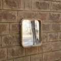 A small square wall mirror with a light natural wood frame mounted on a wall.