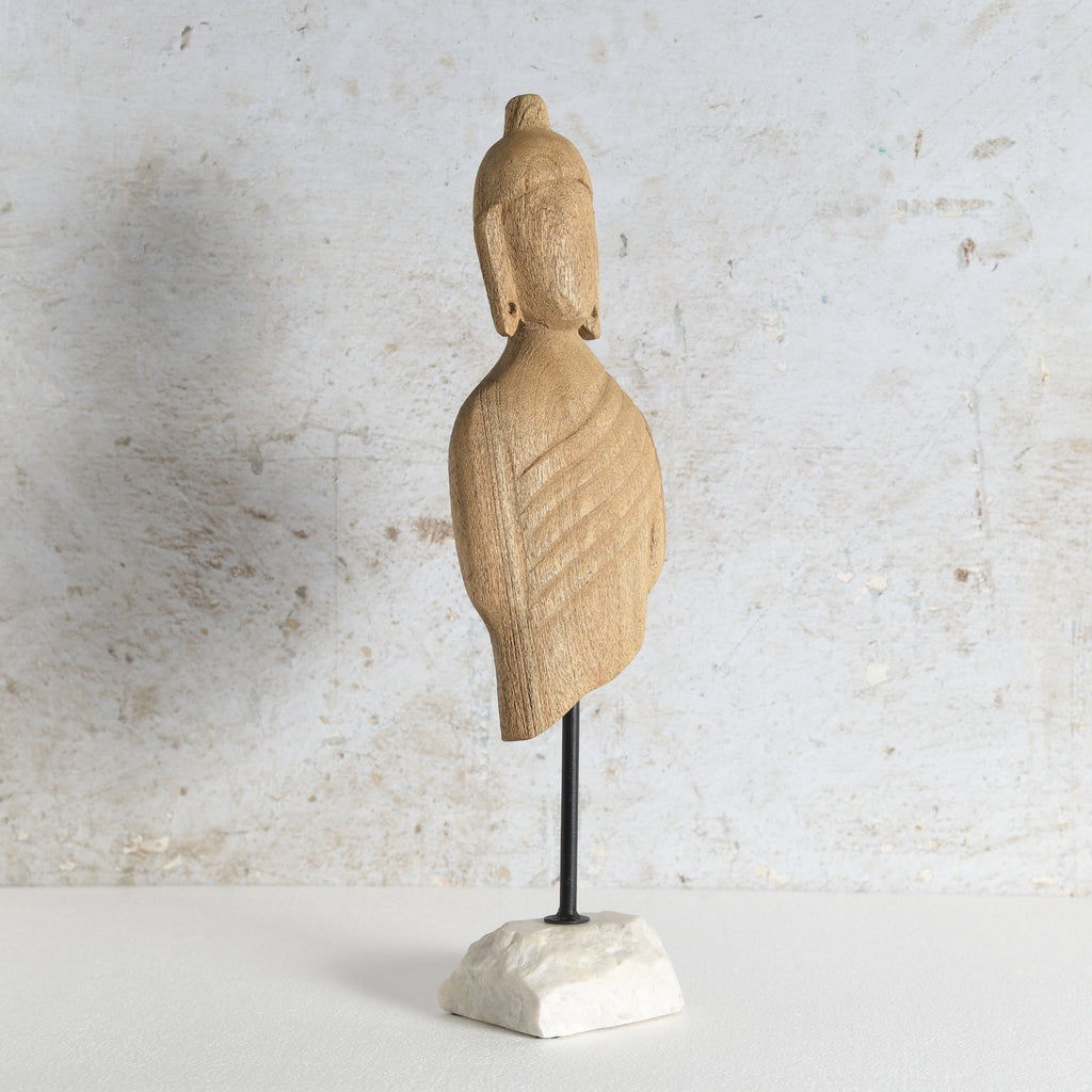Carved wooden Buddha bust sculpture mounted on a black metal stand with a white marble base.