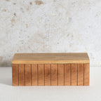 A rectangular wooden box with a slatted front and a flat lid.