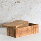 A rectangular wooden storage box with a slatted front and lid.