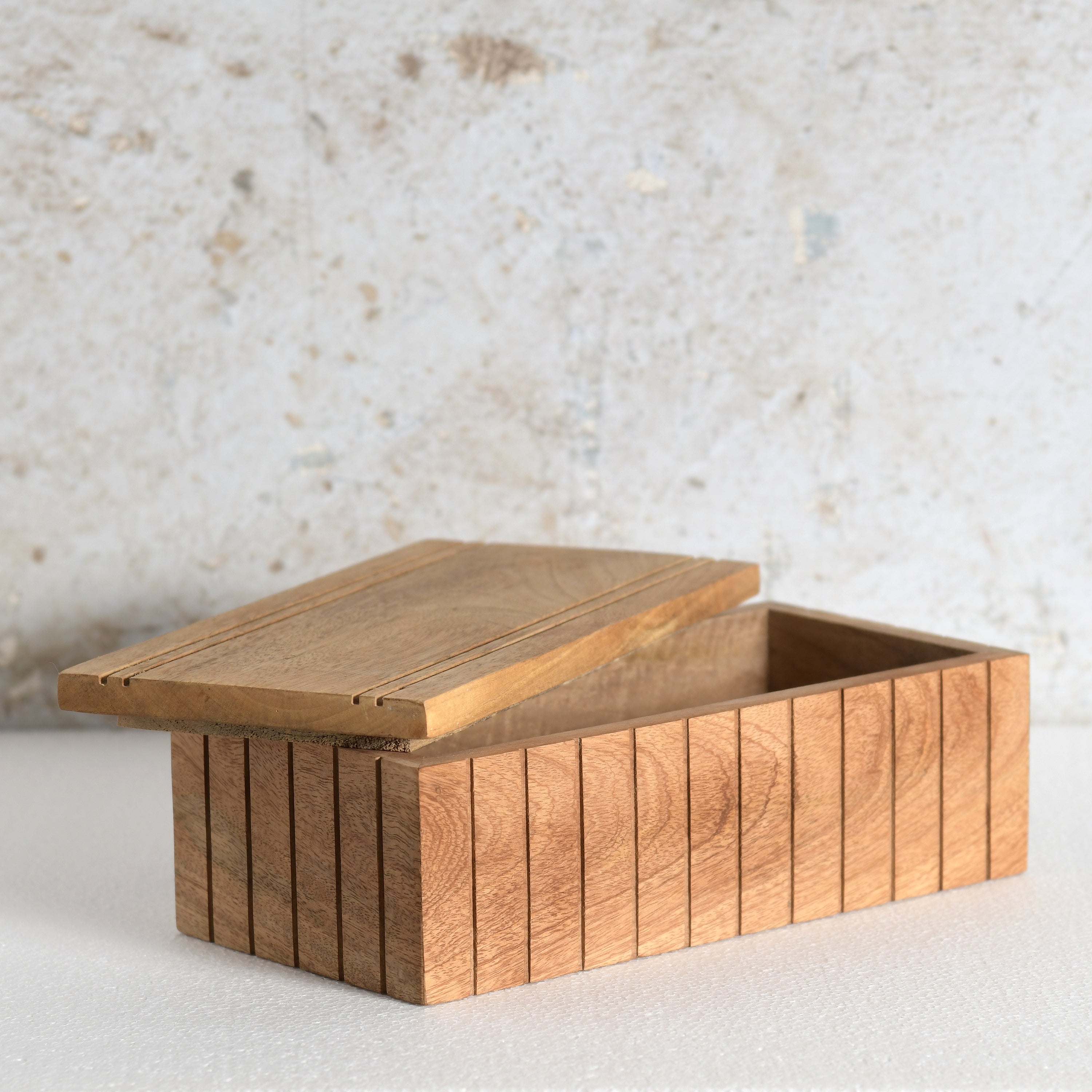A rectangular wooden storage box with a slatted front and lid.