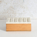 A rectangular box crafted from sheesham wood and a white marble top featuring a grid of small geometric cutouts.