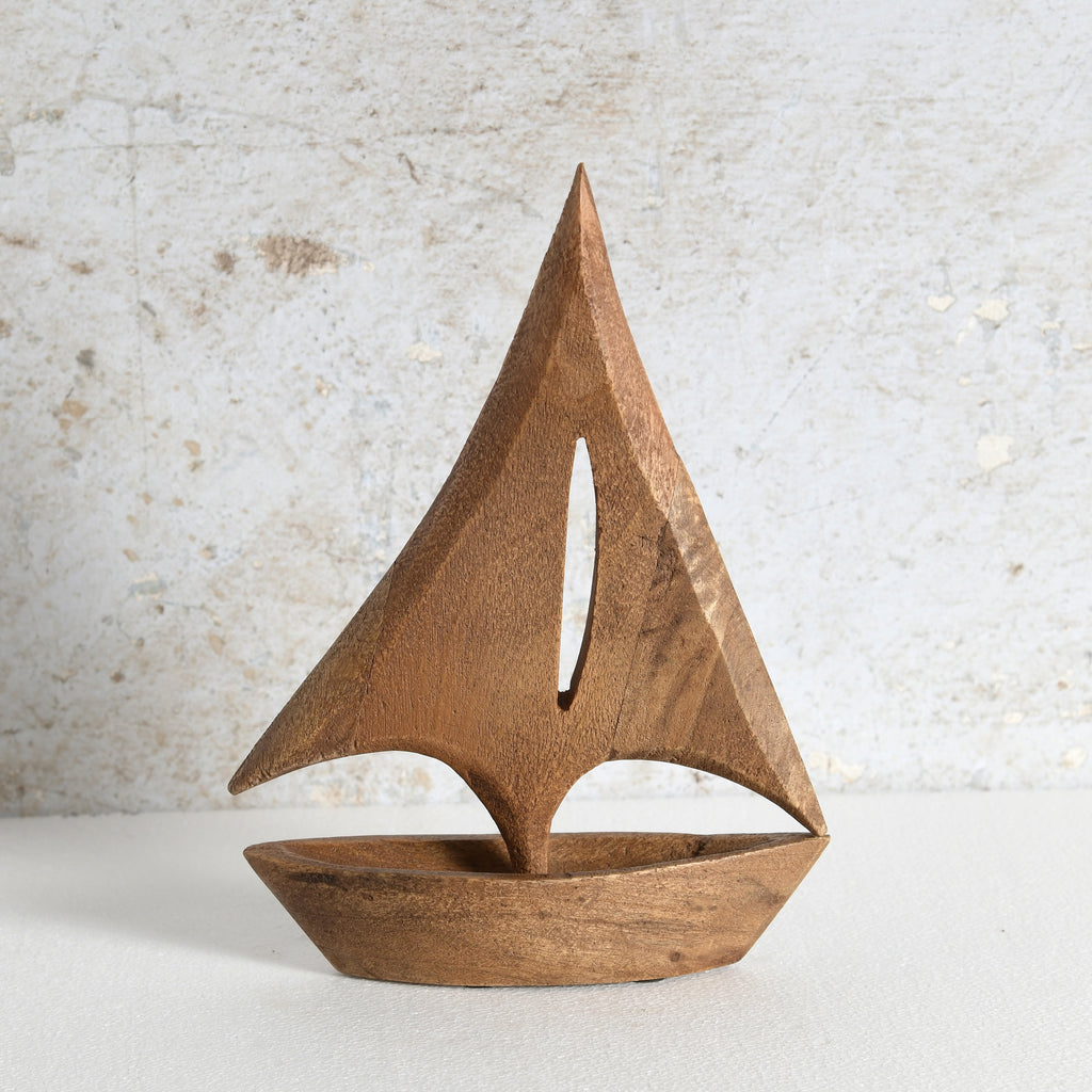 A minimalist wooden sailboat sculpture with a warm medium-brown finish, perfect for living room shelf.
