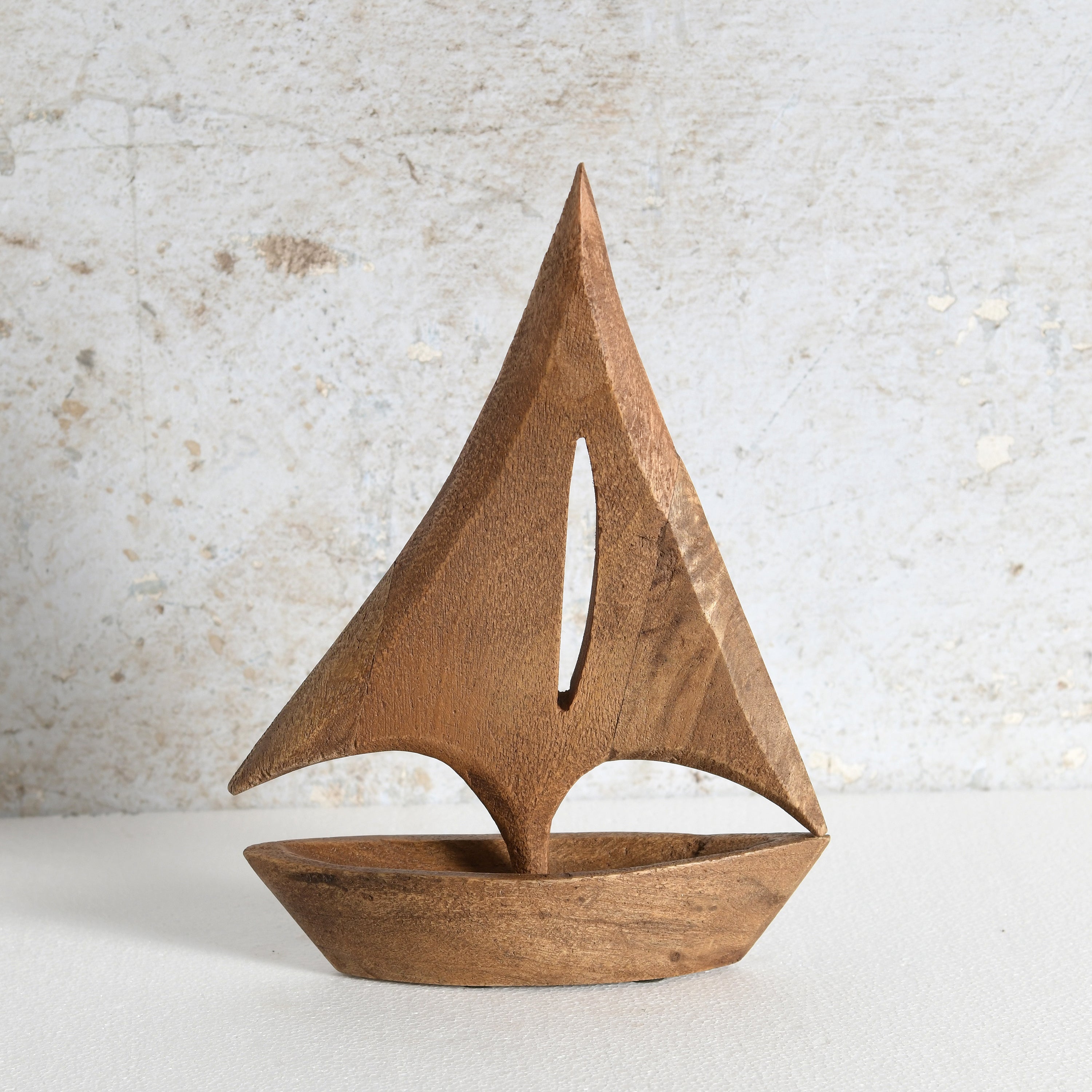 A minimalist wooden sailboat sculpture with a warm medium-brown finish, perfect for living room shelf.
