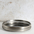 A round metal mirror tray with side handles for decorative use.