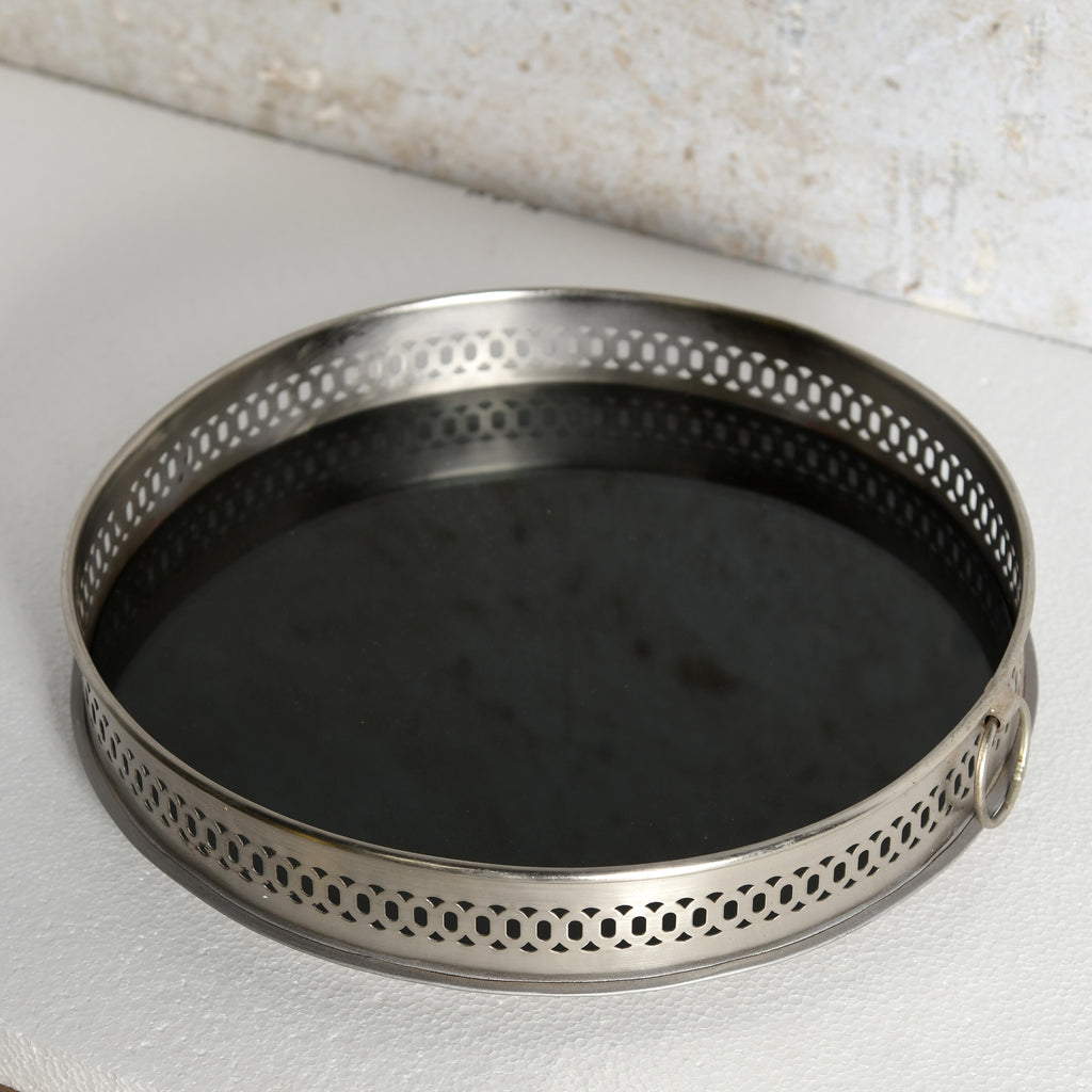 A round metal mirror tray for decorative use.