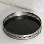 A round metal mirror tray for decorative use.