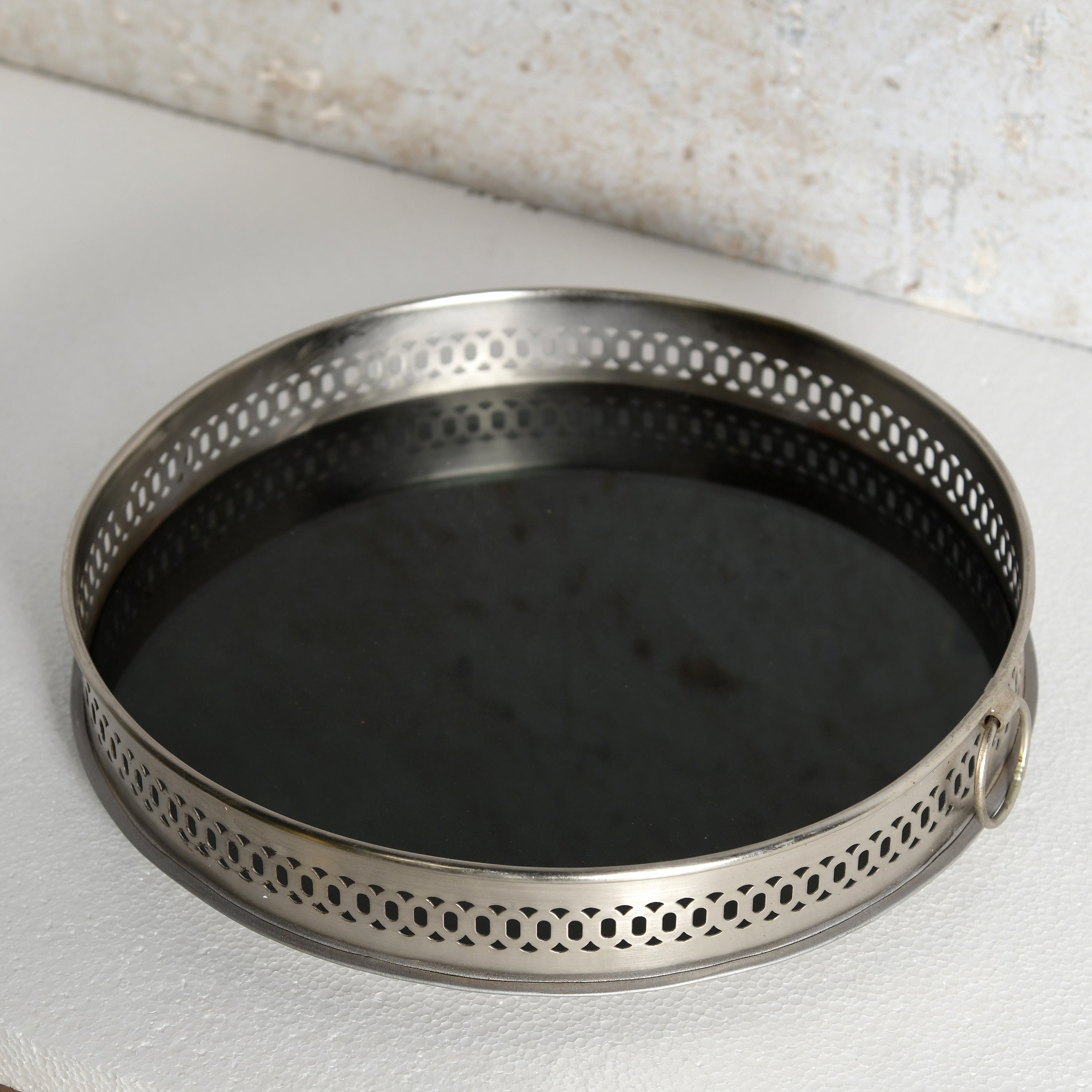A round metal mirror tray for decorative use.
