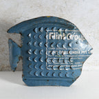 A vintage blue fish-shaped sign with raised circular patterns crafted from recycled metal.