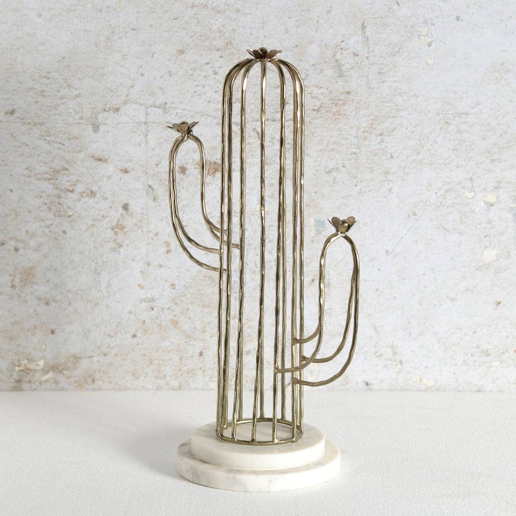 A cactus-shaped metal candle holder with a vertical wire cage body, two curved arms, small bird finials at the tips, and a round white marble base.