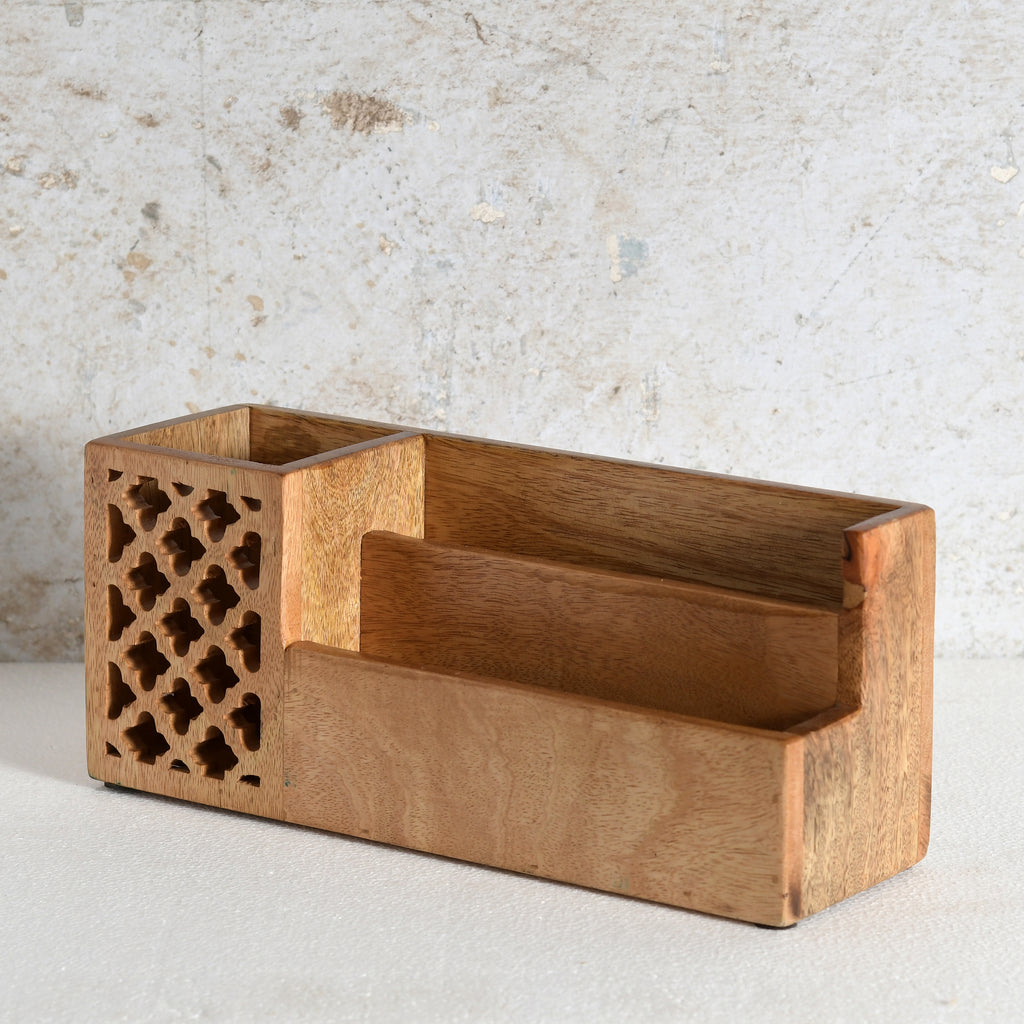 A rectangular wooden desk organizer with a warm medium-brown finish, featuring a decorative lattice cutout panel on one end and three open storage compartments.