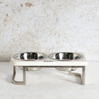 An elevated double pet feeder and water bowl stand with stainless steel bowls and legs.