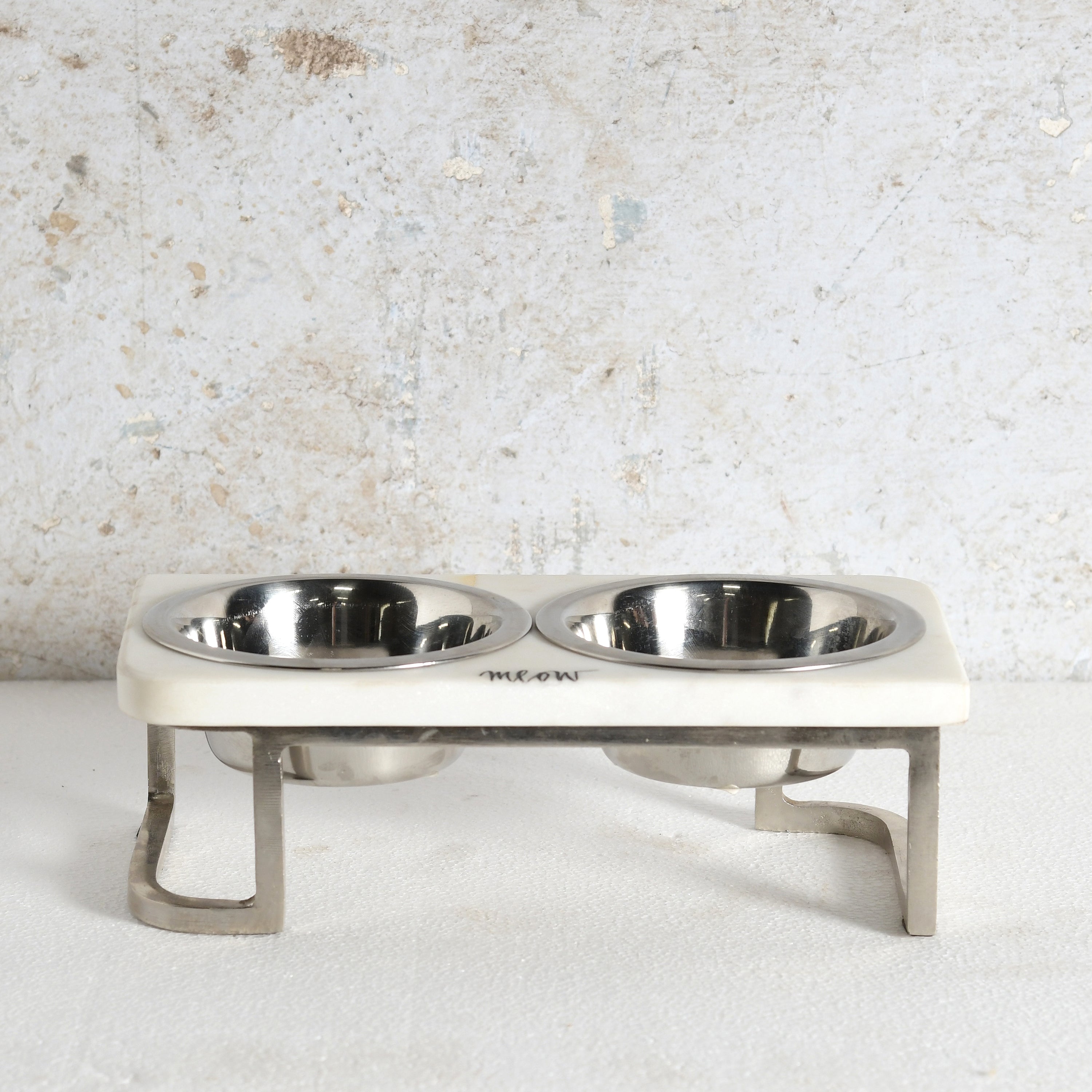 An elevated double pet feeder and water bowl stand with stainless steel bowls and legs.