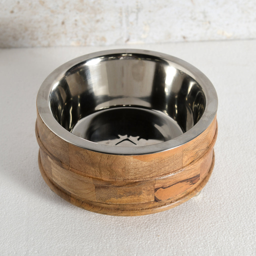 A pet feeder with a brushed stainless steel interior and a natural wood outer base.