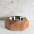 A modern octagonal wooden pet feeder bowl with a stainless steel interior.