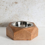 A modern octagonal wooden pet feeder bowl with a stainless steel interior.