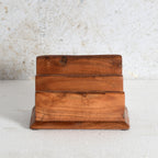A small three-tier wooden napkin holder made of warm medium-brown wood with visible grain and knots.