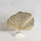 Decorative golden leaf made of iron with white marble base.