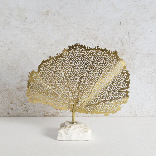 Decorative golden leaf made of iron with white marble base.