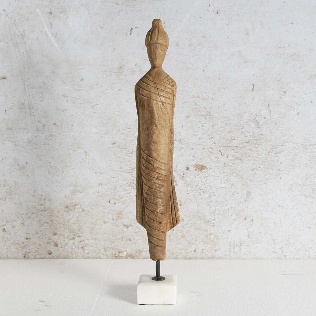 Wooden monk figure with white marble base.