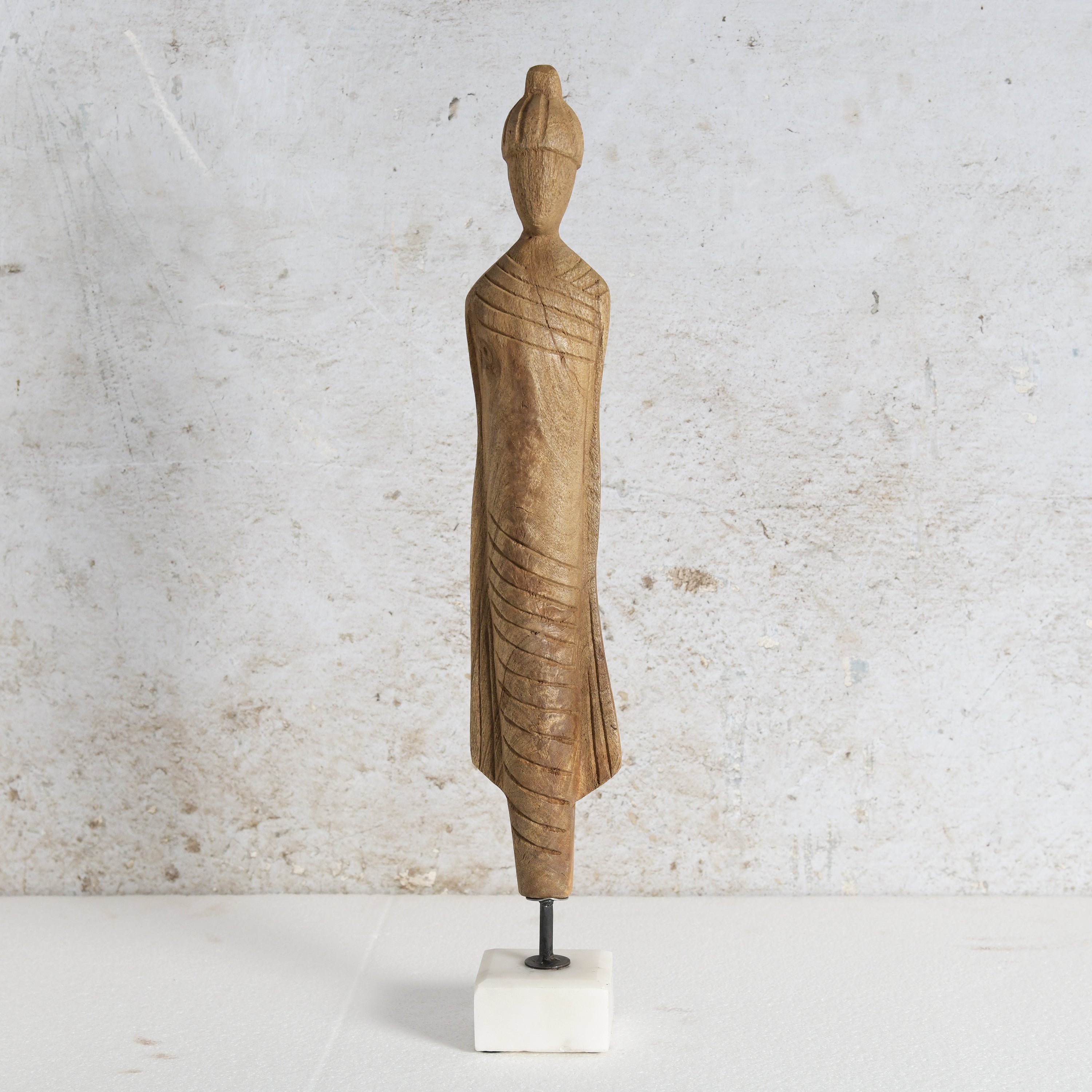 Wooden monk figure with white marble base.