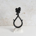 Iron showpiece in black finish with white marble base.