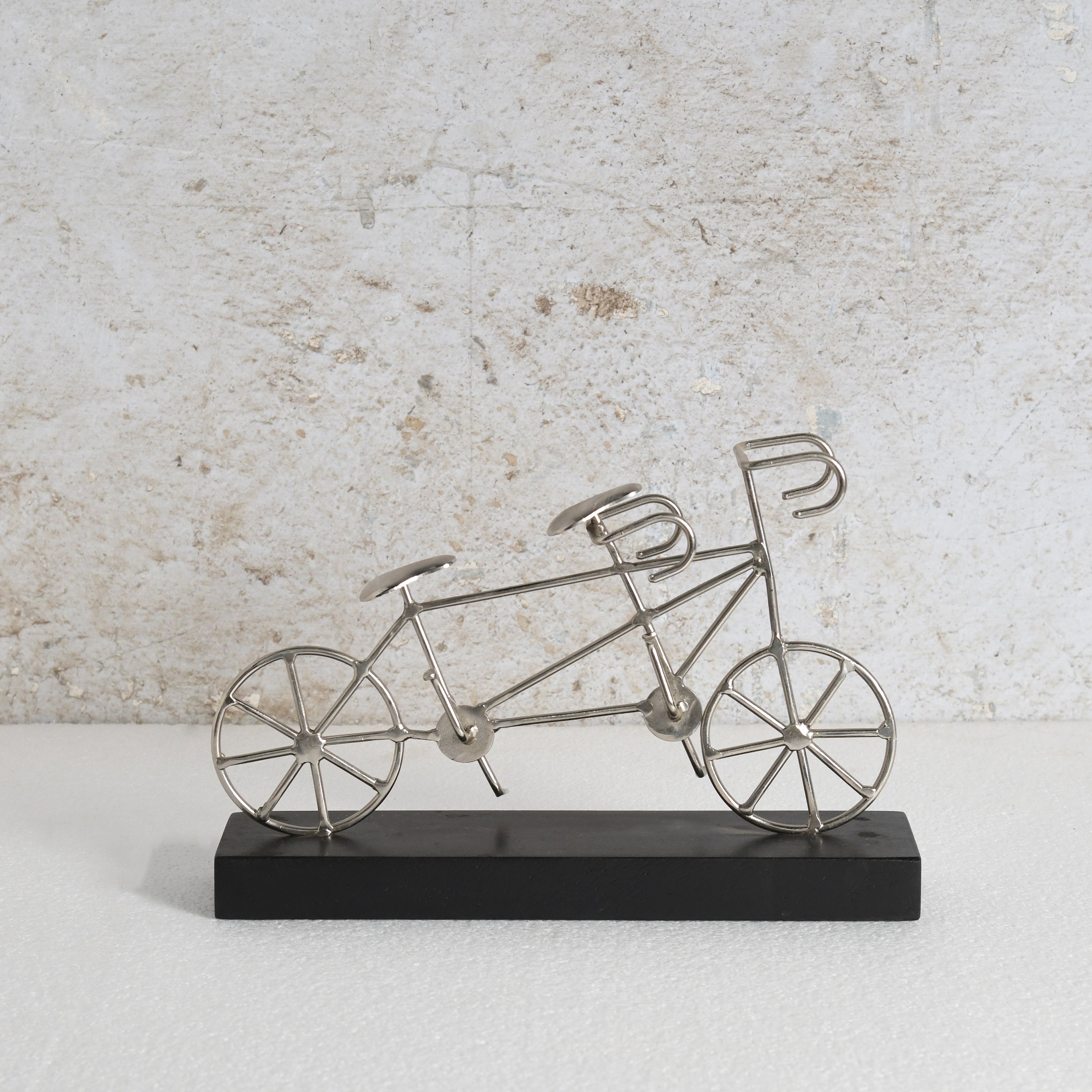 Iron bicycle decor item with black base.