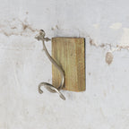 Metal anchor shaped hook mounted on wooden frame